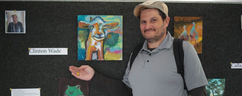 Amici House Artist Posing in Front of His Artwork