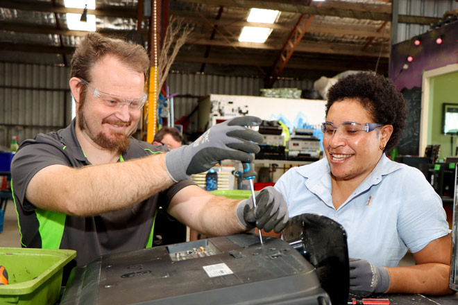 NDIS community support worker helping with some electronic equipment jobs